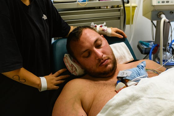 Vader met pasgeboren baby aan het buidelen met ontbloot bovenlichaam