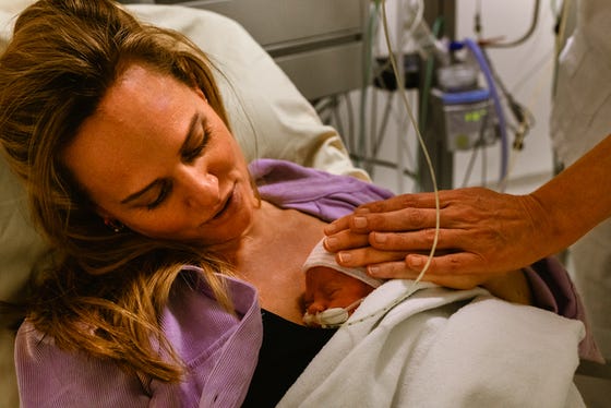 Moeder met pasgeboren baby aan het buidelen