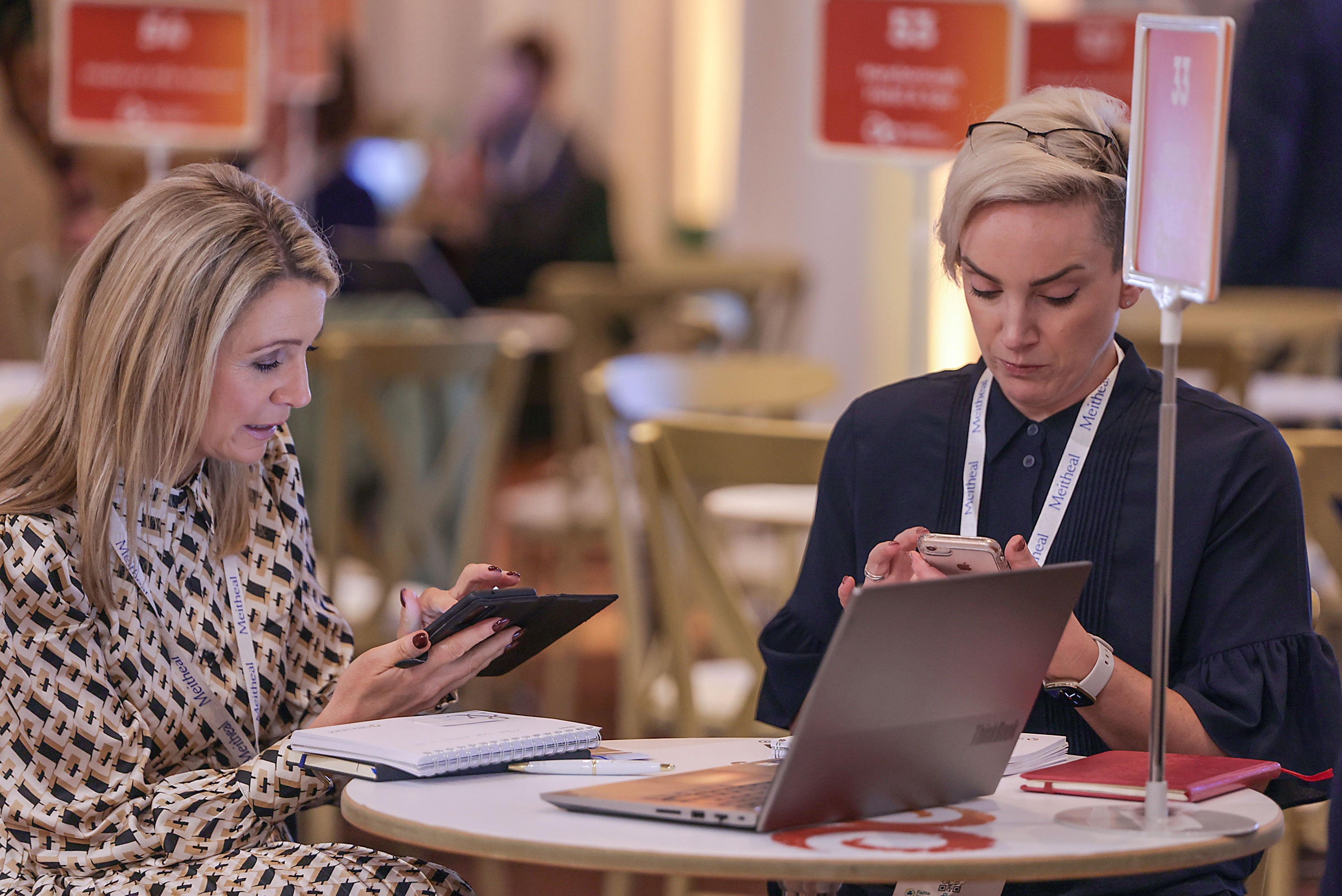 A group of women sitting at a table looking at a laptop