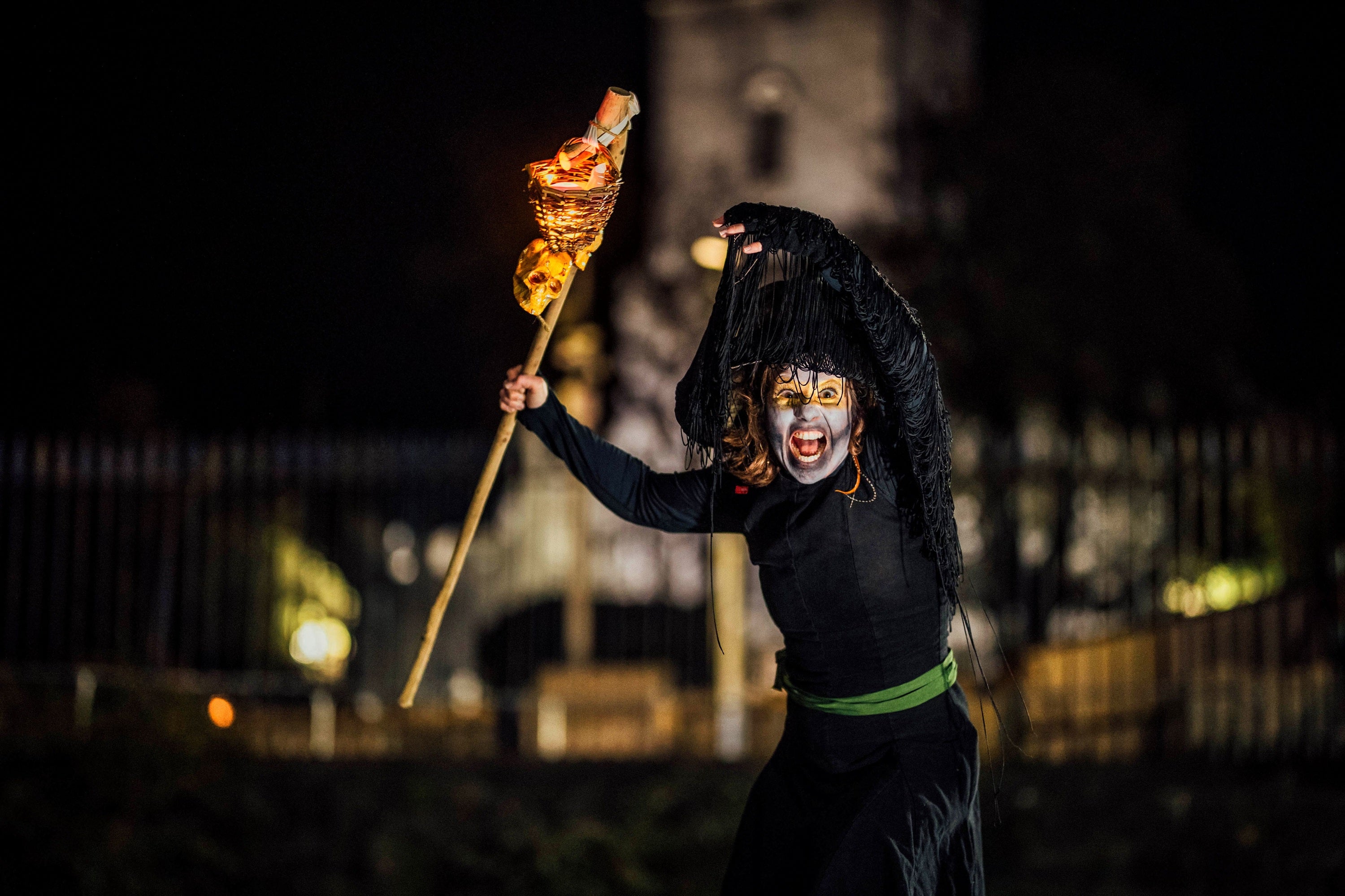A person in a witch costume holding a torch