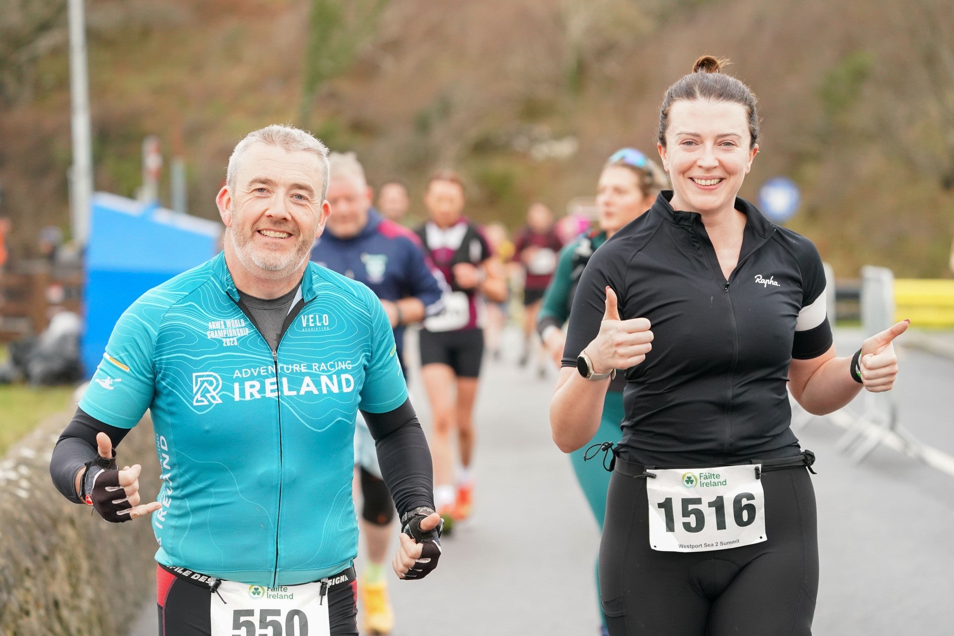Two participants smiling during an outdoor walking or running event.