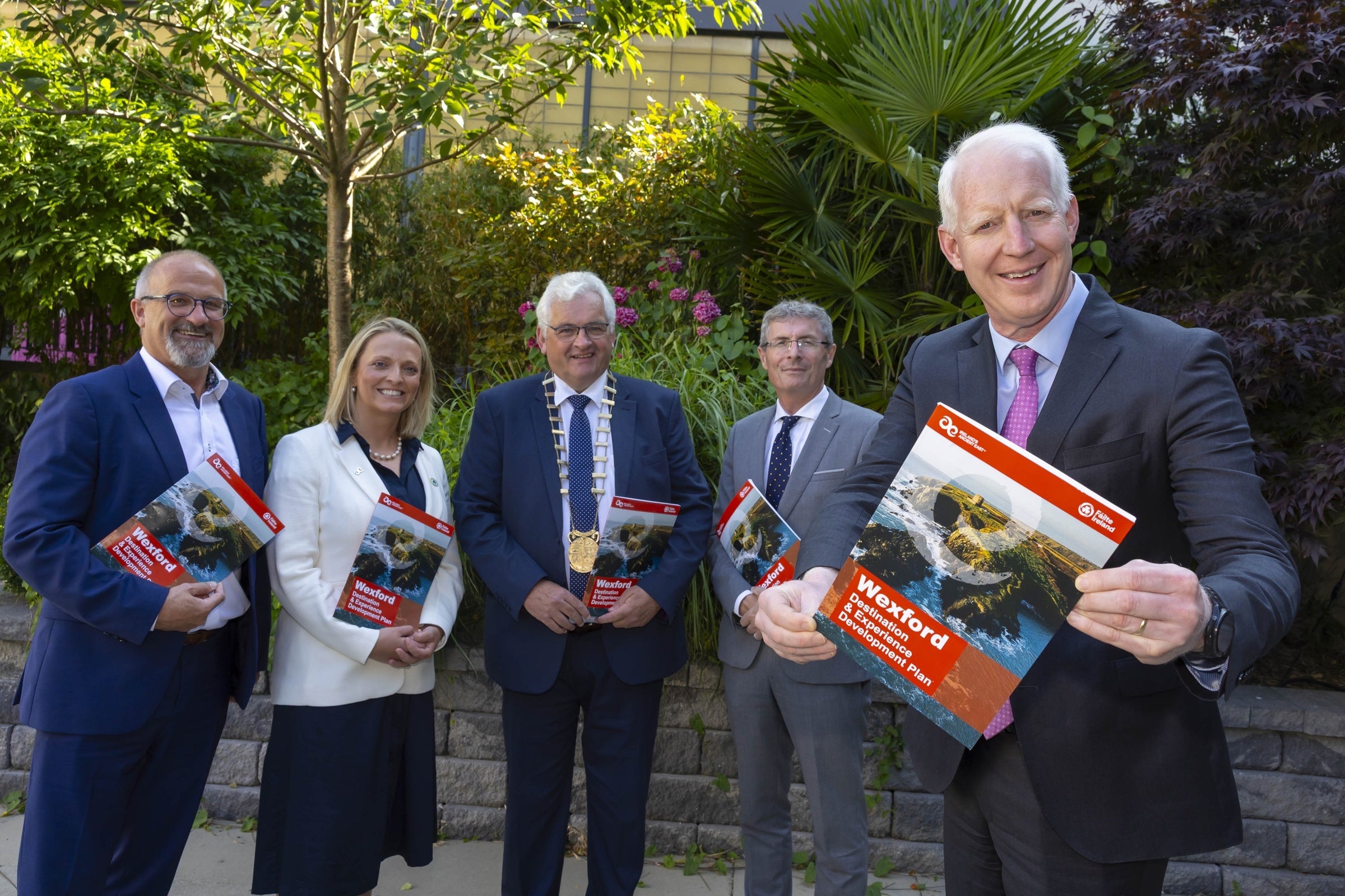 Stakeholders pose for photo holding copies of DEDP document