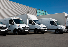 Bílé dodávky zaparkovaných před budovou