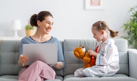 Žena a dieťa hrajúce sa na lekára