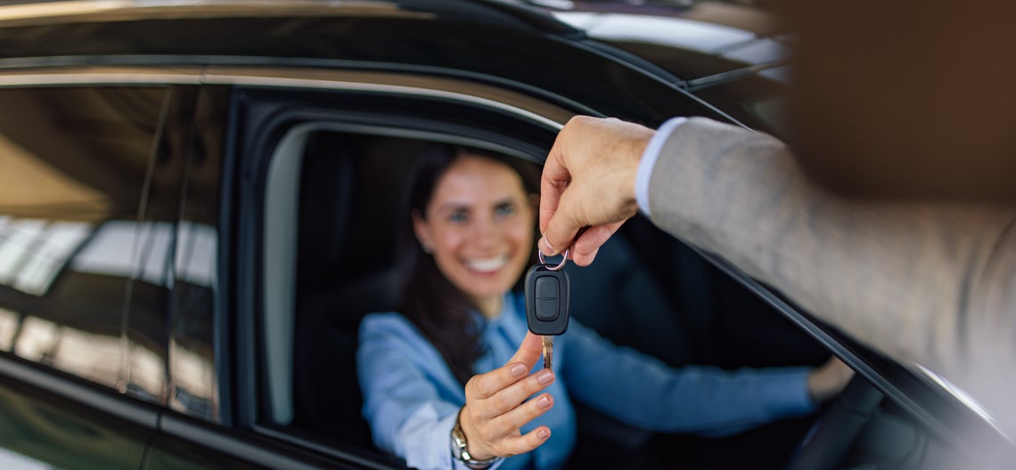Ruka podávajúca žene kľúč od auta