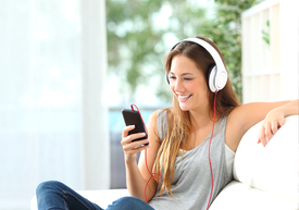 Žena se sluchátky na uších a s telefonem v ruce