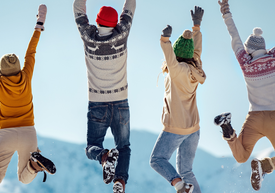 Skupina lidí skákajících do vzduchu na horách