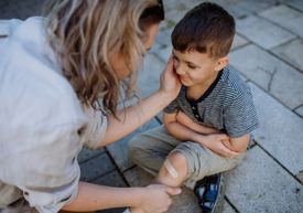 Žena ošetrujúca detské koleno