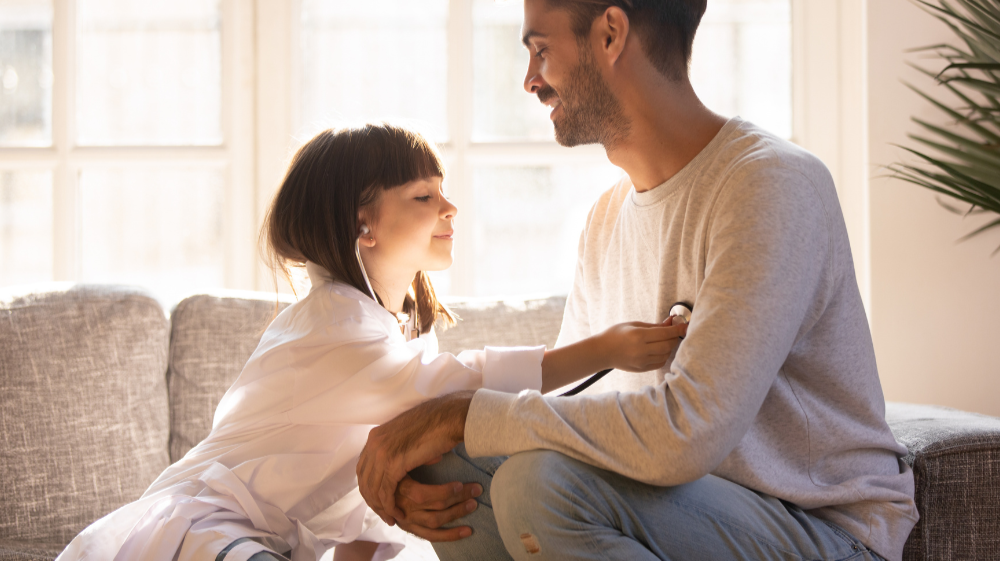 Muž a dievča hrajúci sa so stetoskopom