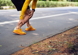 Osoba, ktorá si drží nohu