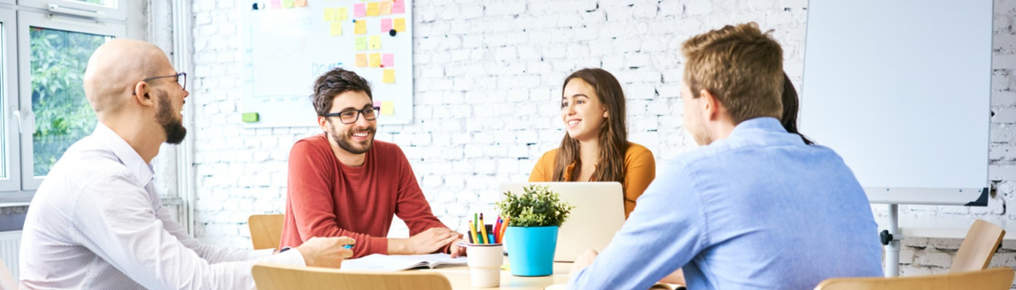 Skupina ľudí sediacich pri stole