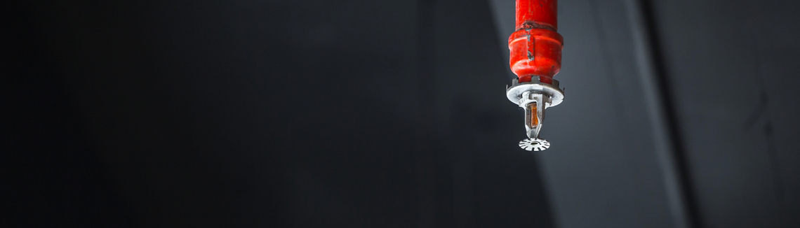 czerwony tryskacz w ciemnym pomieszczeniu, zabezpieczenie przeciwpożarowe zdjęcie w poziomie