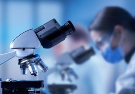 Detailní záběr ženy u mikroskopu