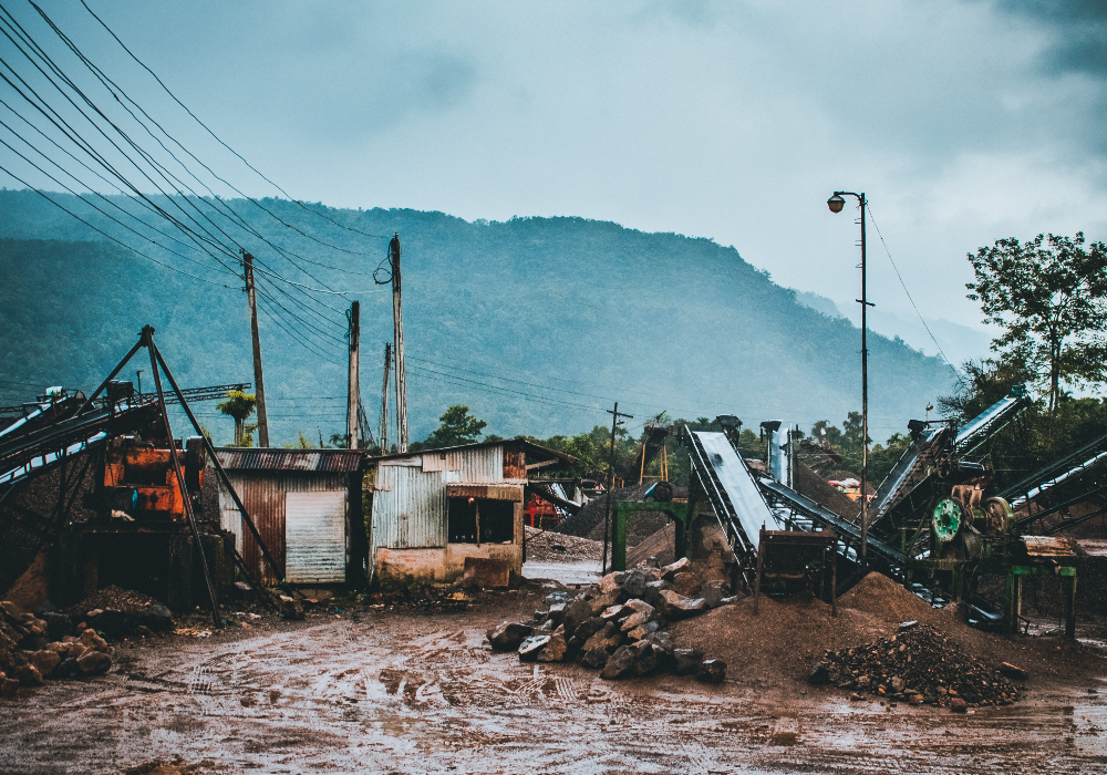 Továreň s hromadou skál a horou v pozadí