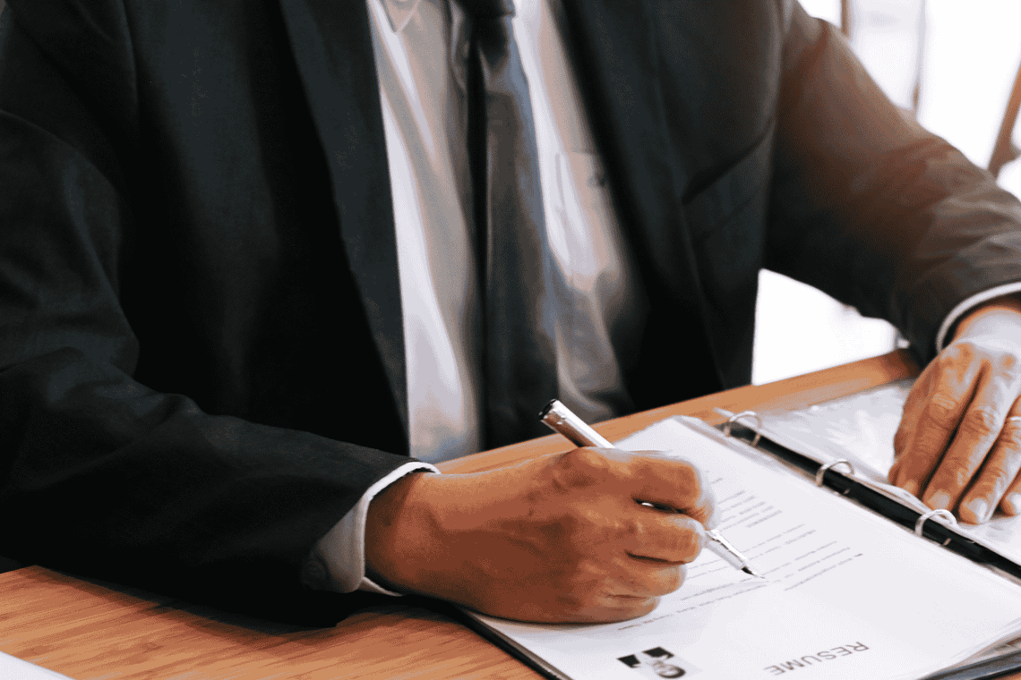 Mężczyzna w garniturze czytajacy CV