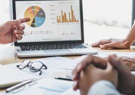 Detailný záber na ruky ukazujúce na koláčový graf na prenosnom počítači