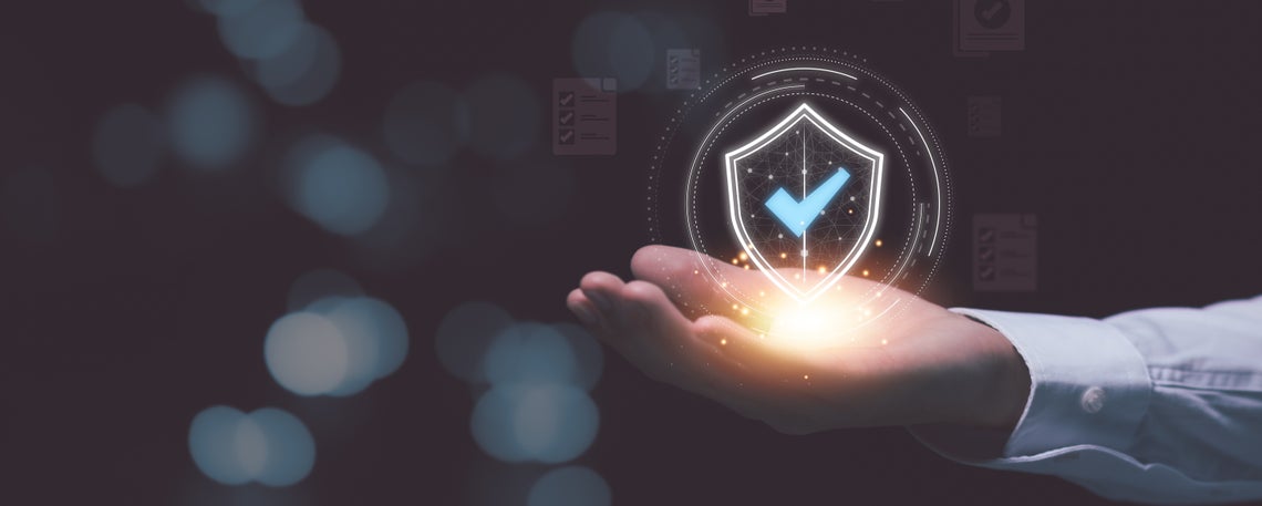 Ruka držiaca svietiaci štít s kontrolným znakom