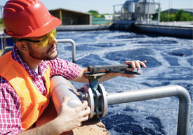 Pracownik oczyszczalni ścieków w pomarańczowej odzieży ochronnej