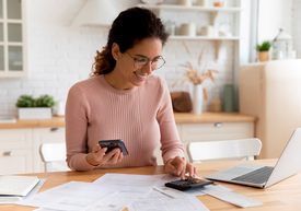 Žena používající kalkulačku a notebook