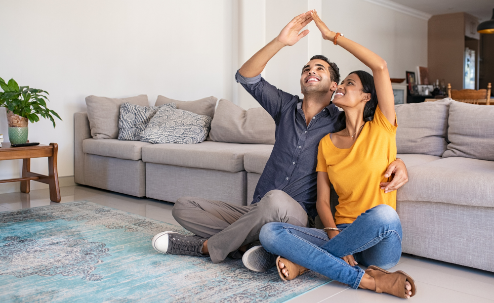 Muž a žena sedia na zemi so zdvihnutými rukami