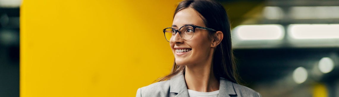 Młoda uśmiechnięta kobieta w okularach.