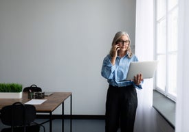Žena držící notebook a telefonující