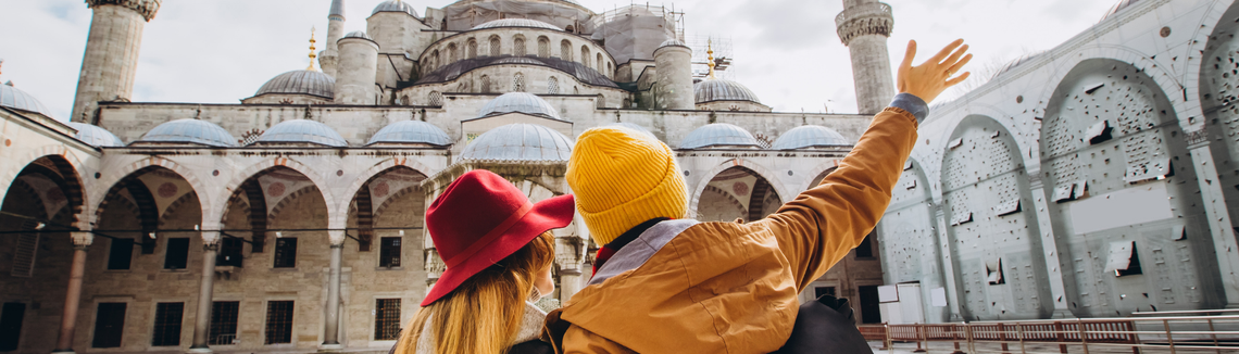 Mężczyzna i kobieta w kapeluszach patrzący na budynek