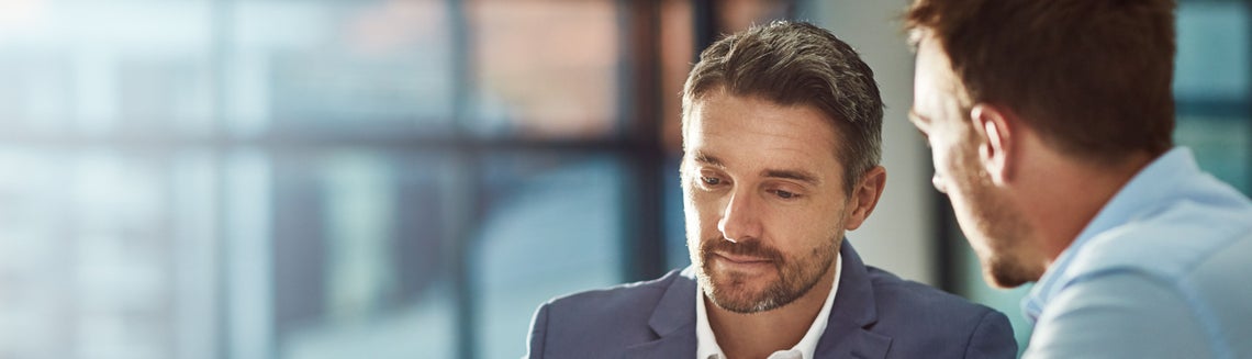 Dva muži, kteří se dívají dolů na něco