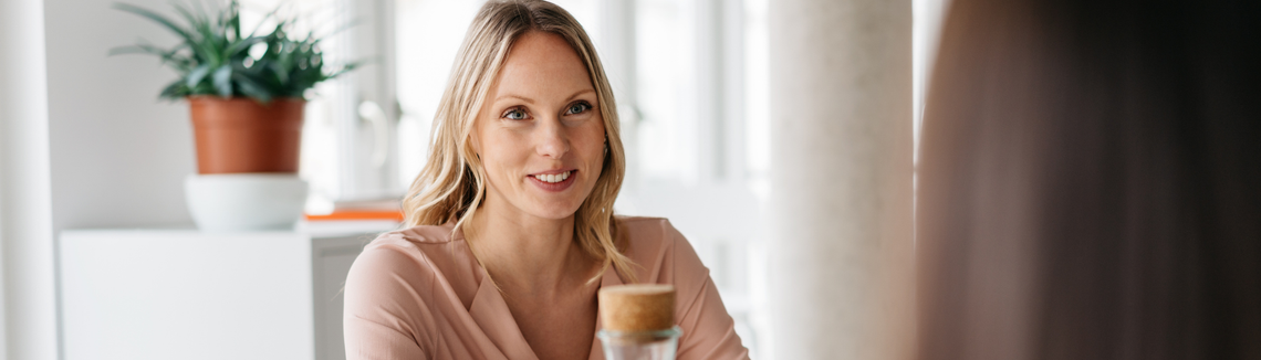 Kobieta uśmiechająca się do osoby na przeciwko