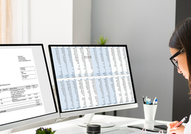 kobieta w biurze przed monitorami komputera, dane finansowe