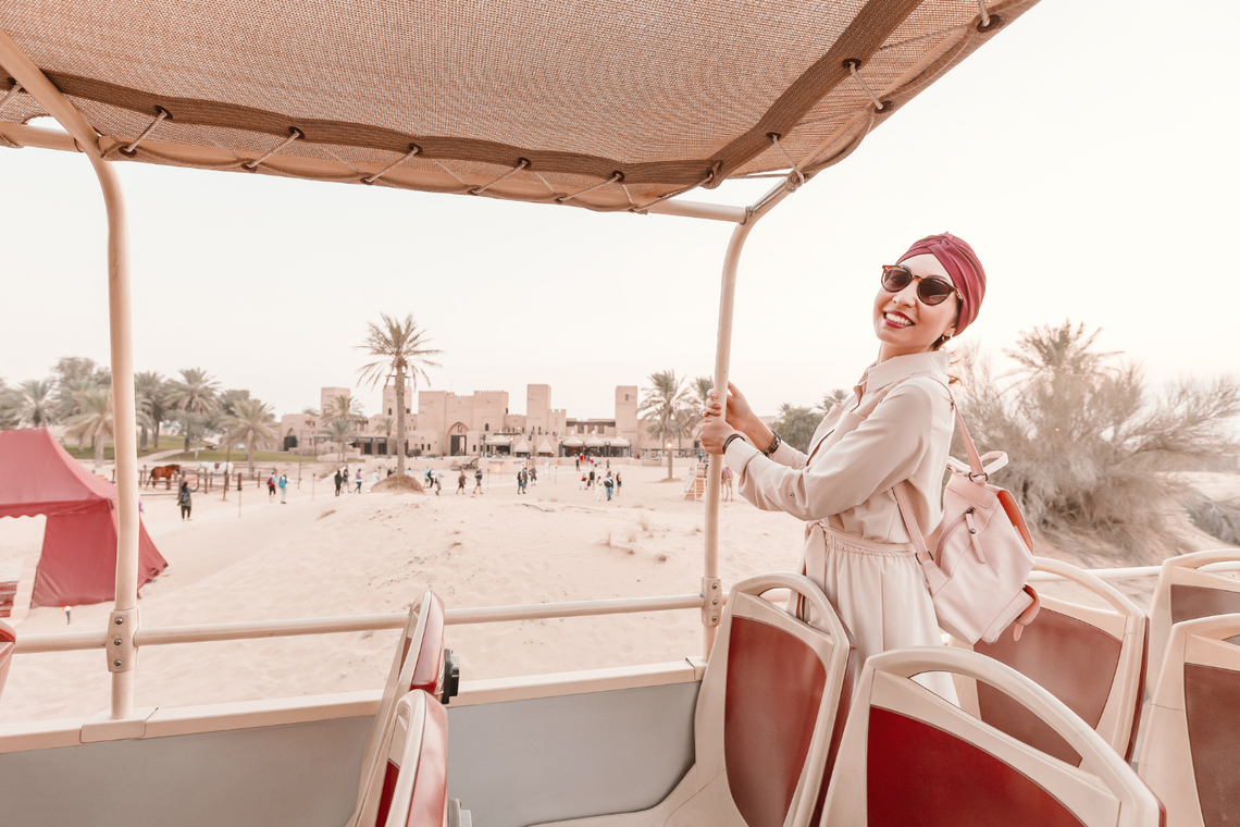 Kobieta w białej sukience i okularach przeciwsłonecznych w autobusie