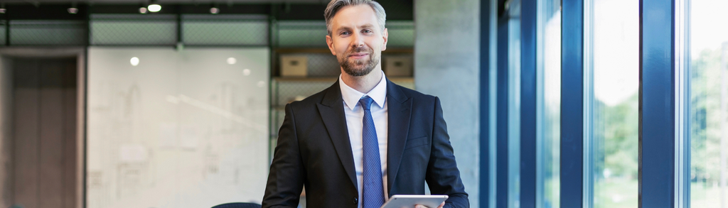 Mężczyzna w garniturze trzymający tablet