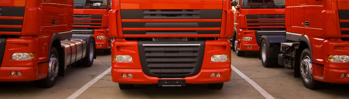 czerwone ciężarówki stojące w rzędach obok siebie