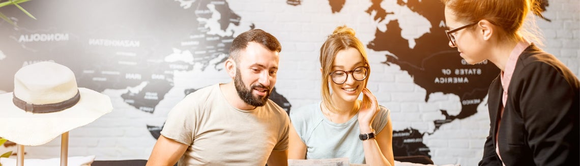 Žena a muž vybírající si dovolenou v cestovní kanceláři