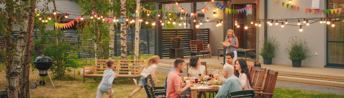 rodzina przy stole, biesiada w rodzinnym ogrodzie , radosna spokojna atmosfera