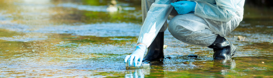 Osoba v modrých rukaviciach, ktorá drží fľašu s vodou