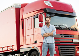 Mężczyzna stojący przed czerwoną ciężarówką
