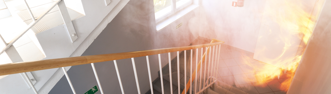 wybuch ładunku w budynku, ogień i dym na klatce schodowej