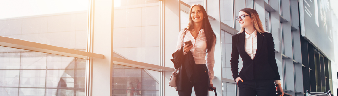 dwie kobiety w podróży służbowej, delegacja, panie z walizkami w korytarzu