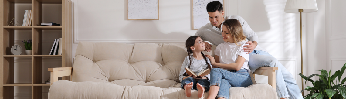 Rodina na gauči prohlížející knihu
