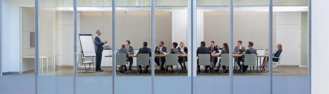 zebranie w firmie, sala konferencyjna widziana przez szybę z zewnątrz