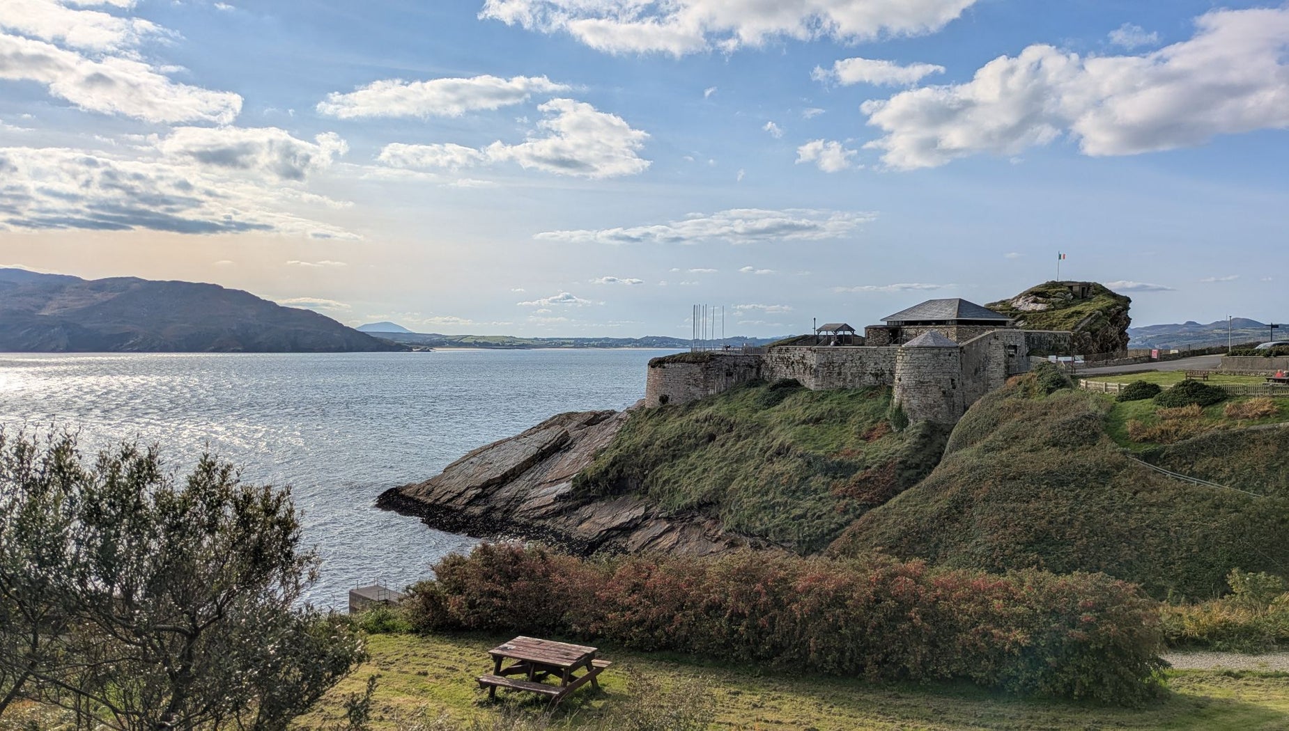 A stone building sitting on a cliff top overlooking the sea