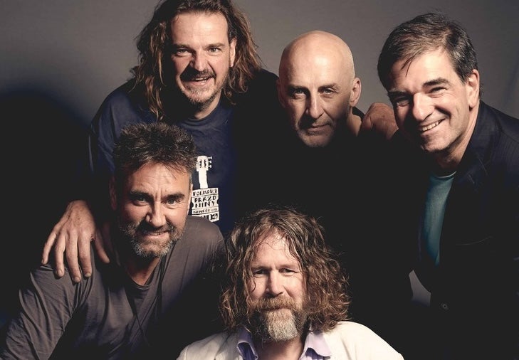 A tight group of 5 smiling men