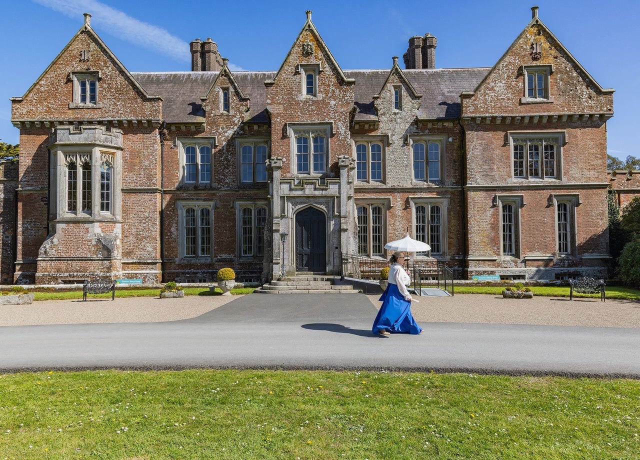 Lady in costume walking in front of Wells House
