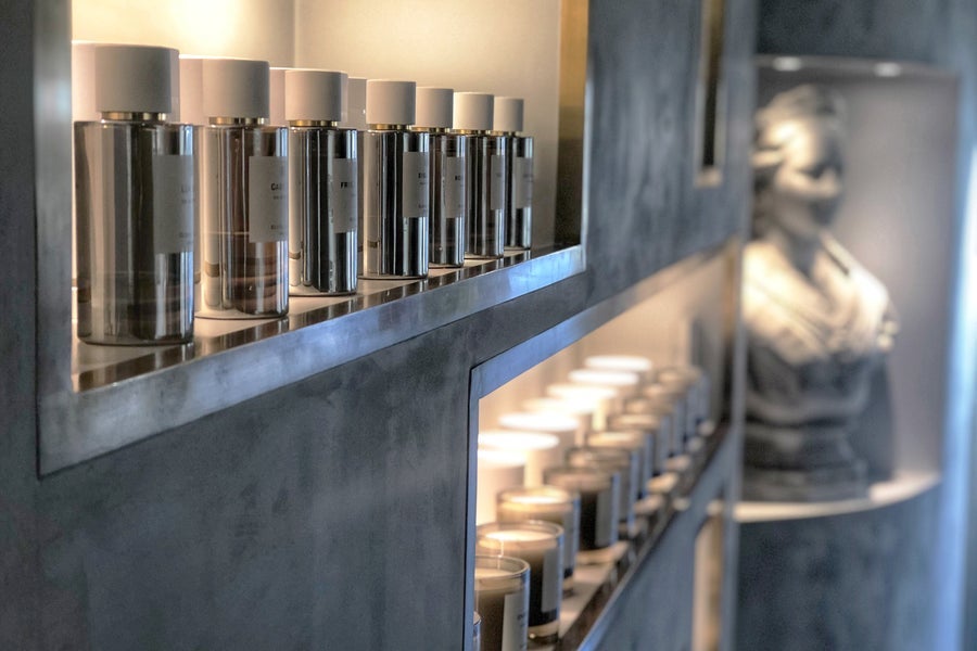 Bright modern shelving with rows of perfumes and candles on display