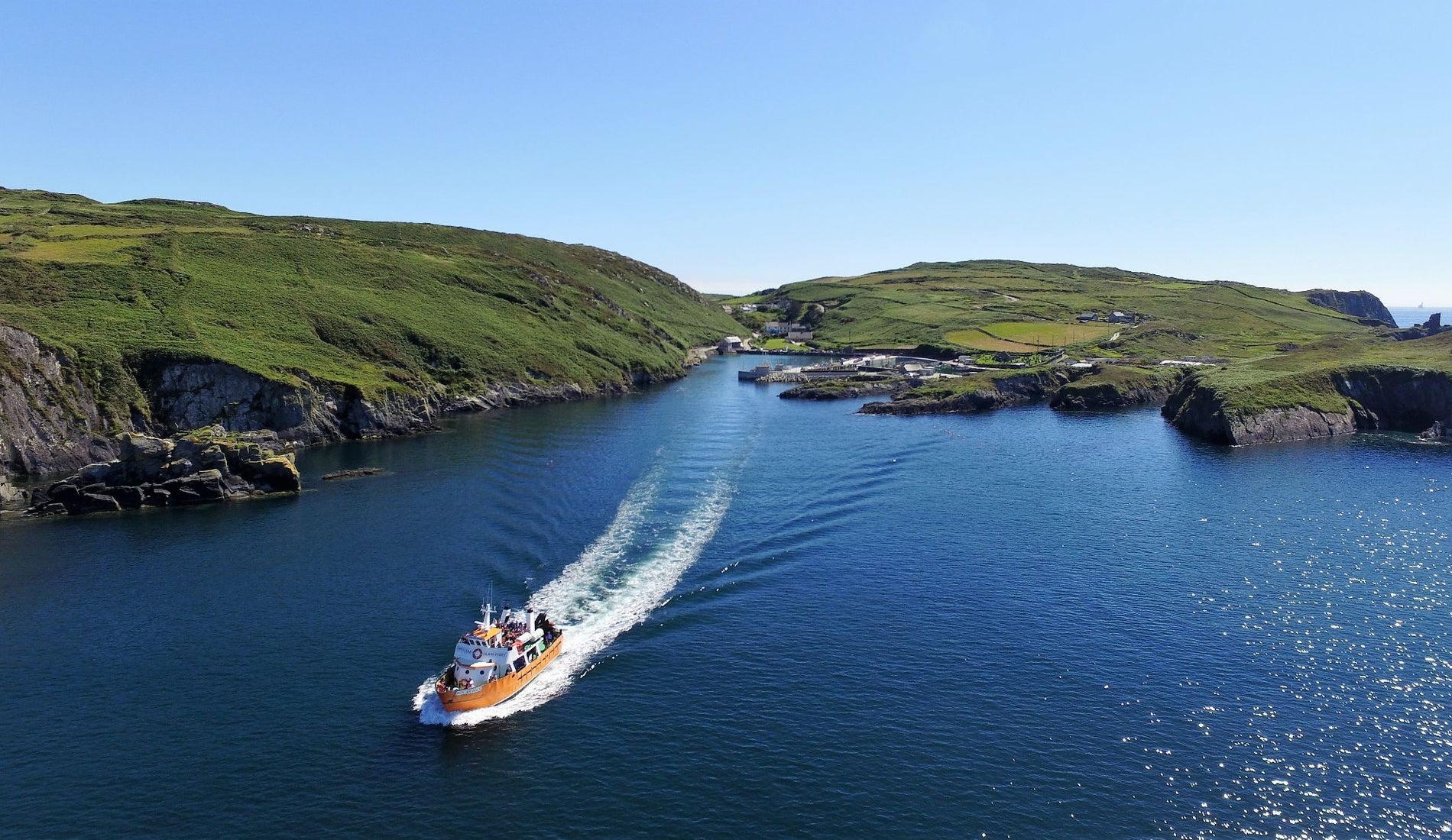A drone image of a ferry sailing away from land