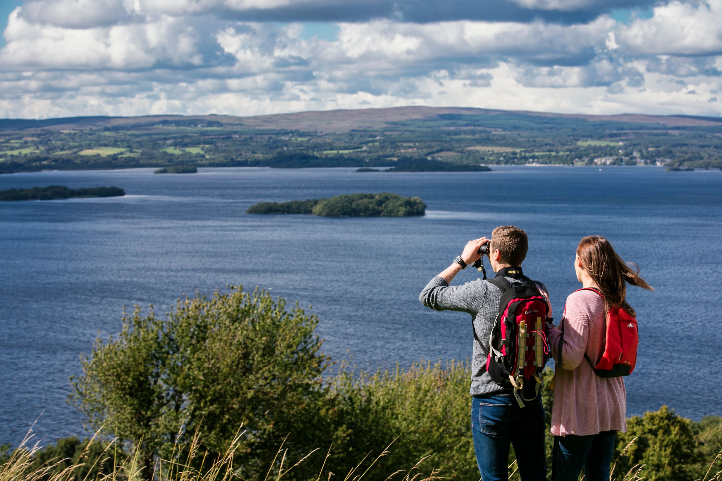 A couple using binoculars to look out over Lough Derg, County Tipperary