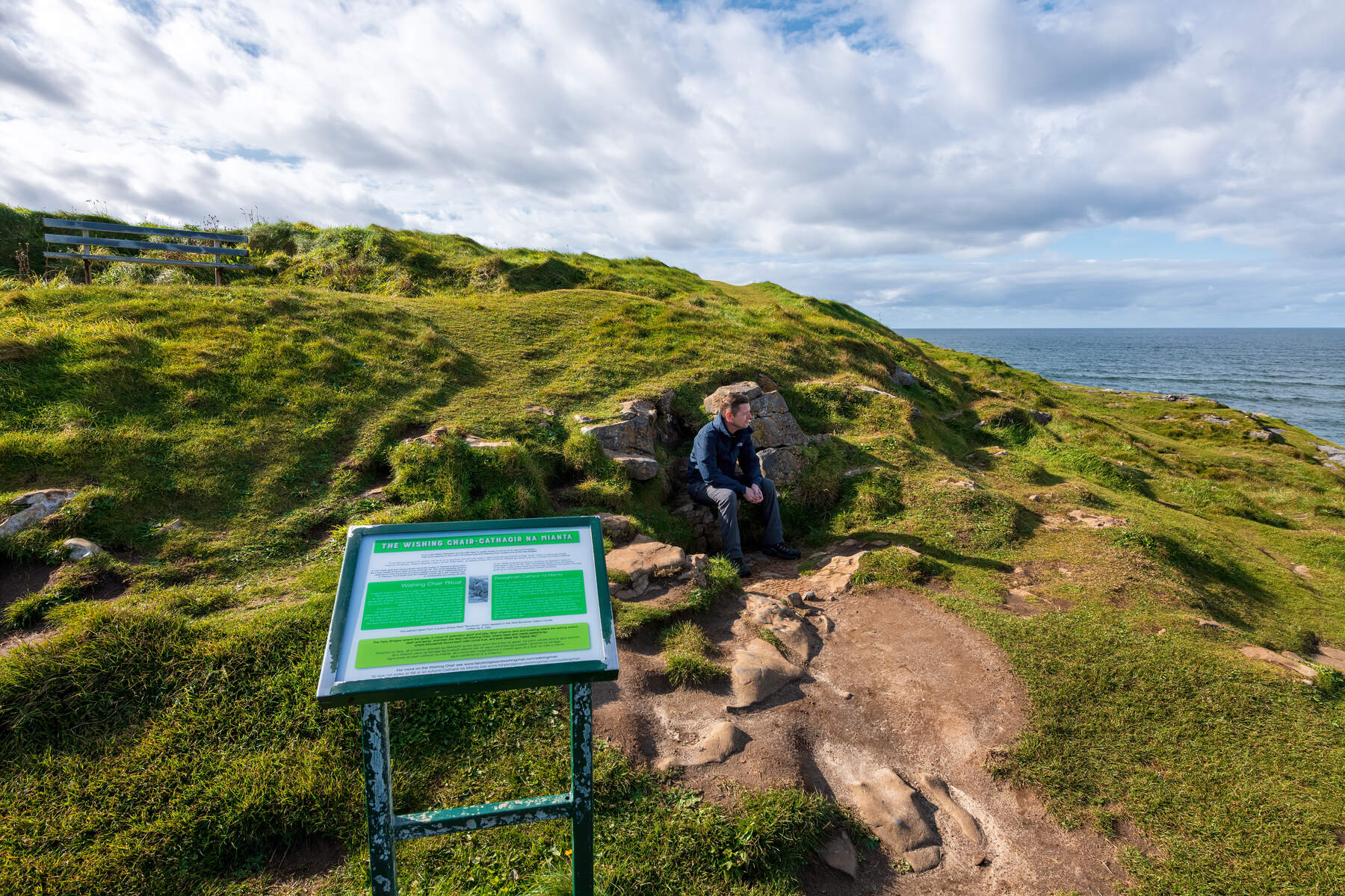 A man sitting on the Wishing Chair on the Rougey Walk in Bundoran, Donegal