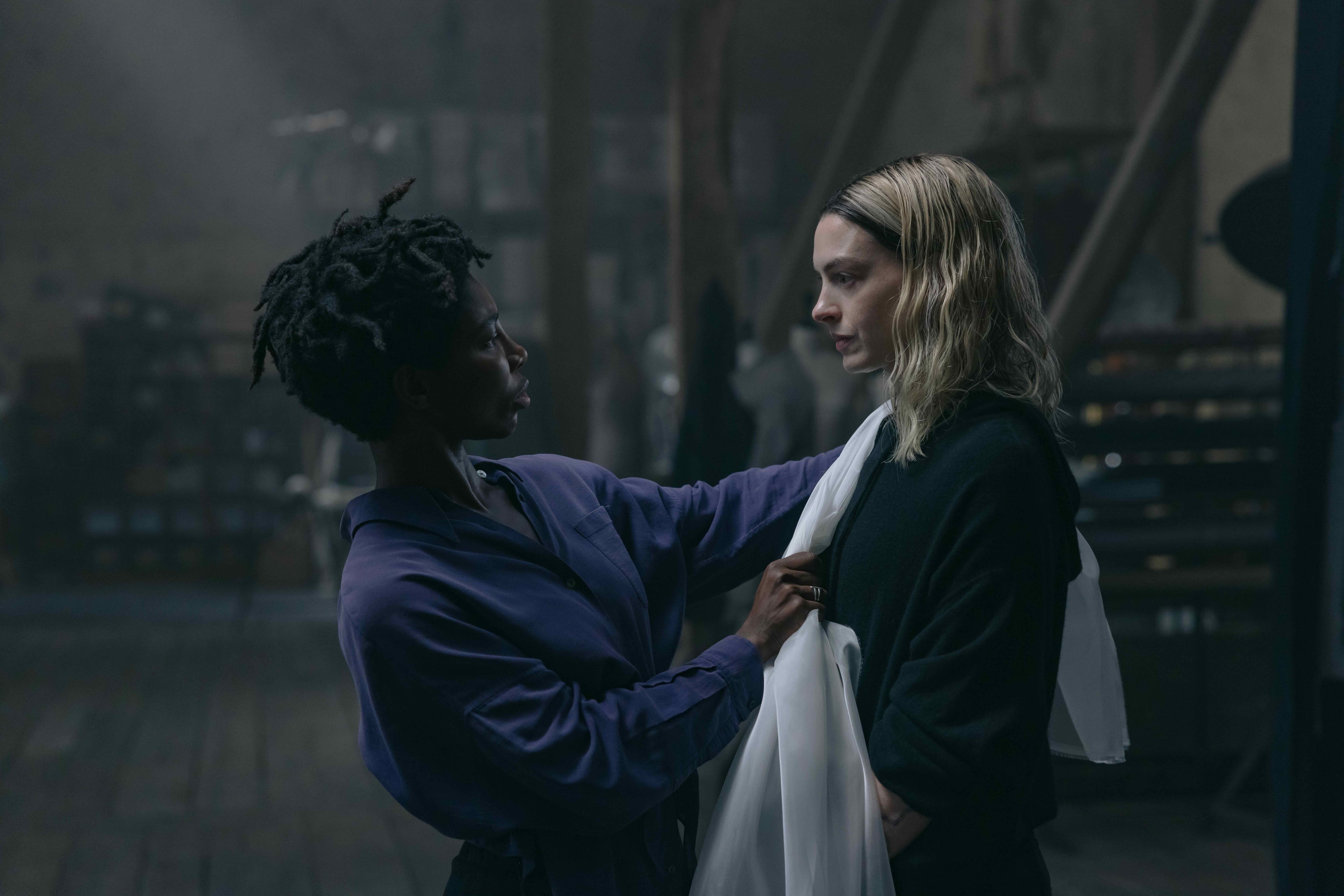 A woman is putting a shawl on another woman.