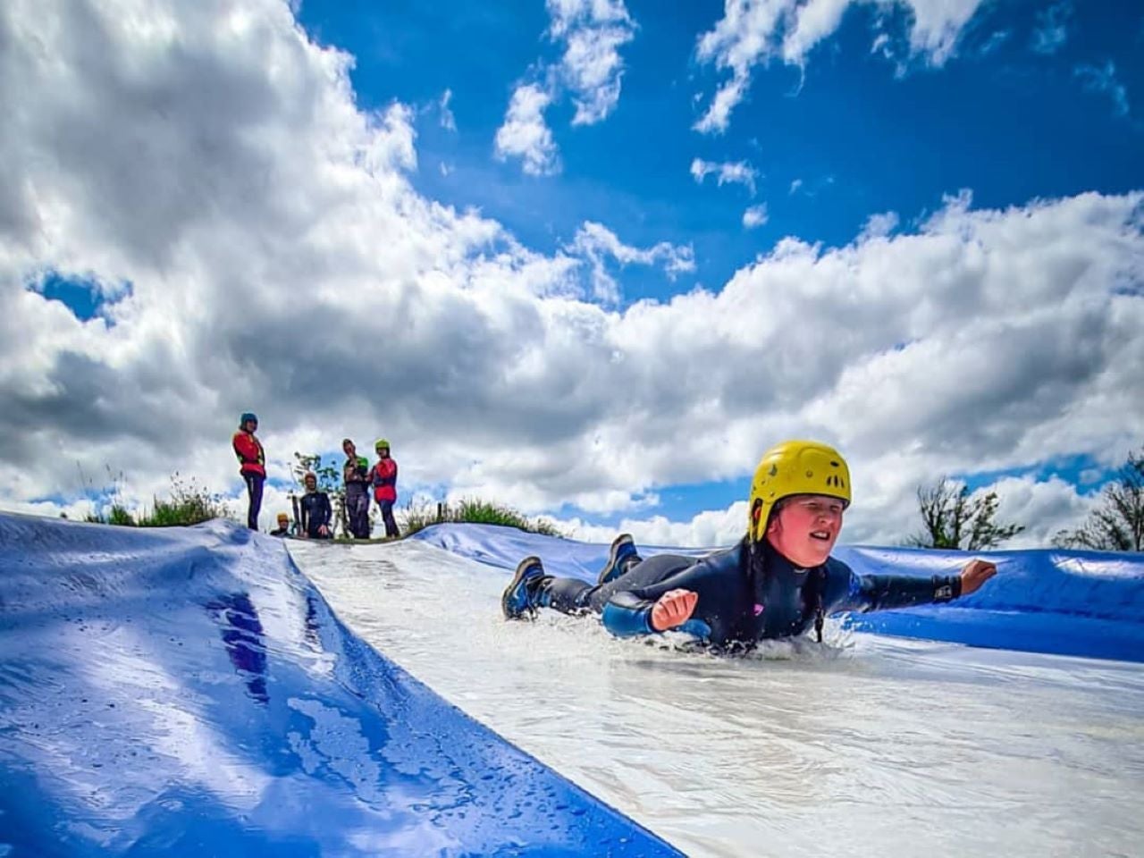 A child slides down the mud splash slide at Shannon River Adventure